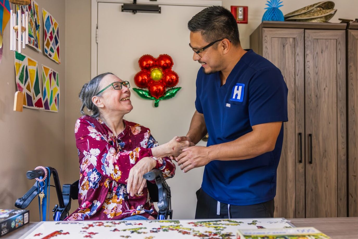 Staff assisting a resident with a puzzle activity