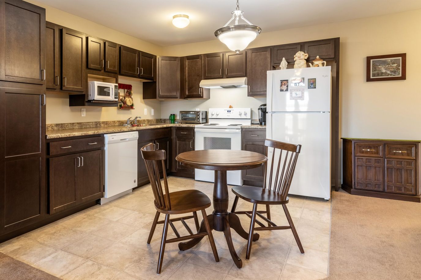 Connect55+ Concord, assisted living in Concord, NH — Modern kitchen with dining table and wooden chairs
