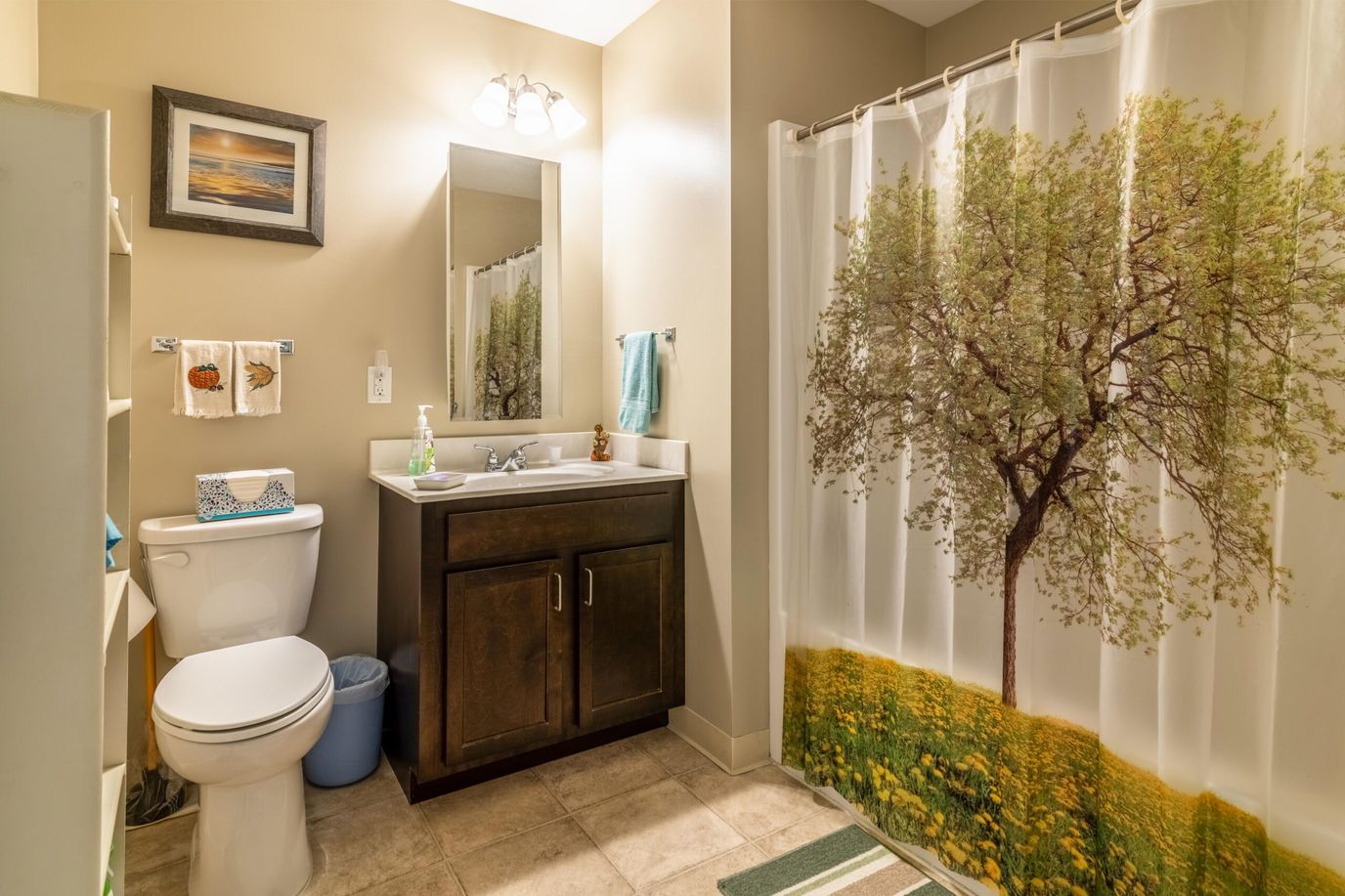 Connect55+ Concord, assisted living in Concord, NH — Bright bathroom featuring a tree-print shower curtain