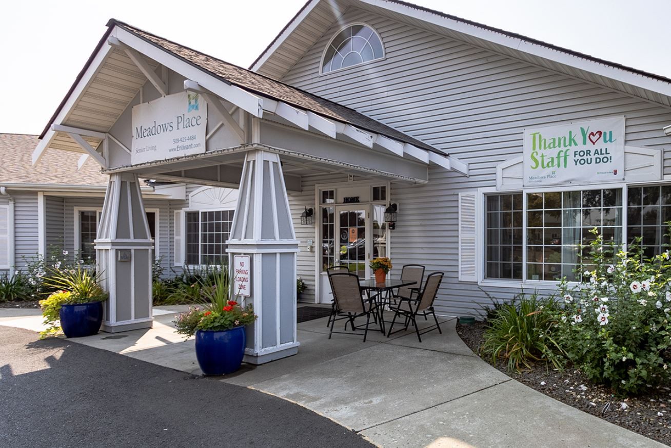 Front entrance of a senior living facility with outdoor seating