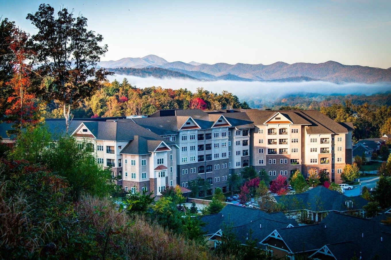 Exterior view of a senior living facility with mountains in the background