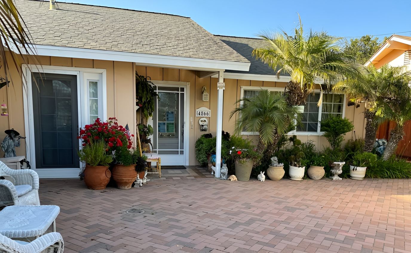 Exterior view of a senior living facility entrance with well-kept plants
