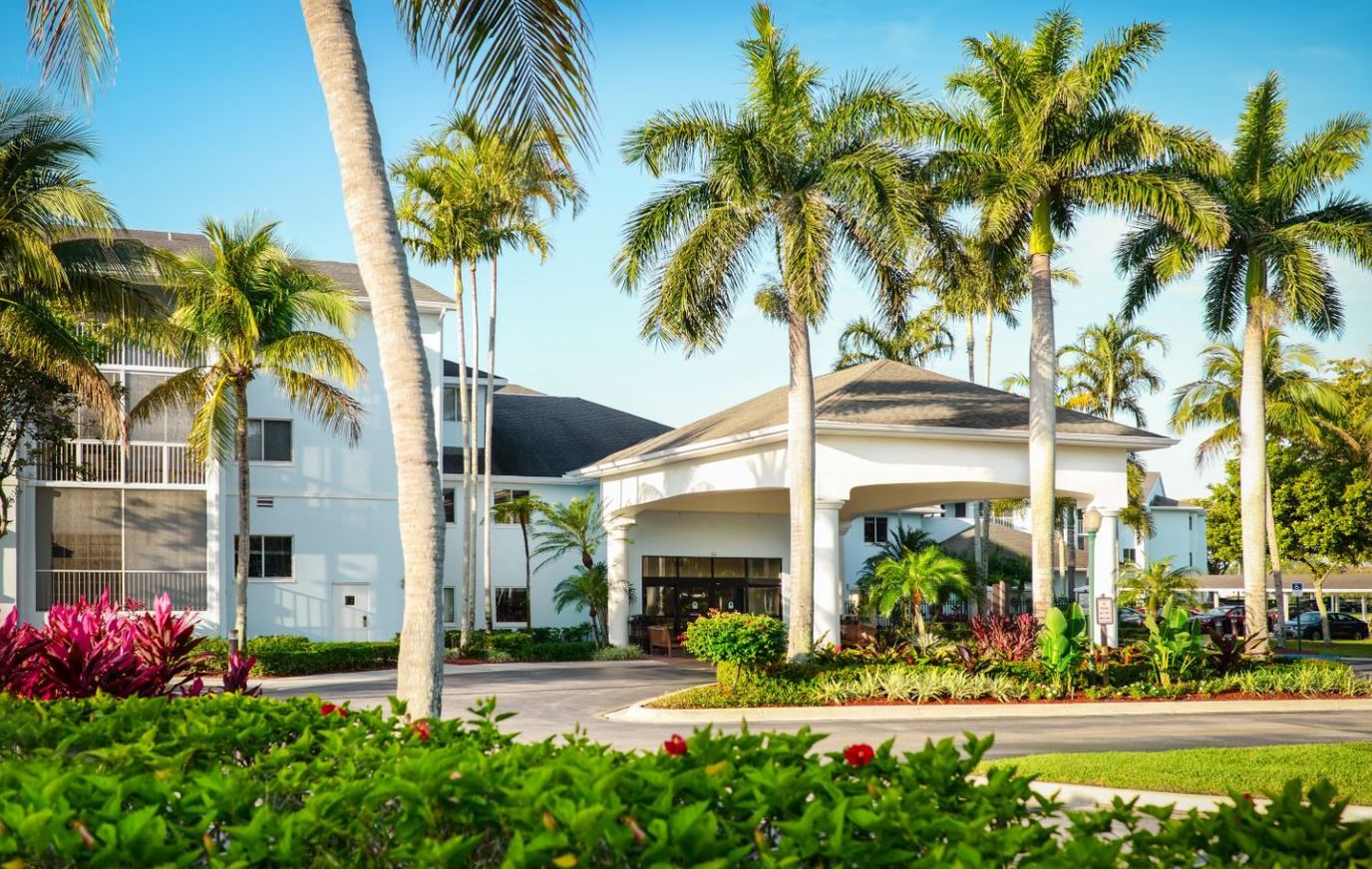 Entrance of Vi at Lakeside Village with palm trees and garden