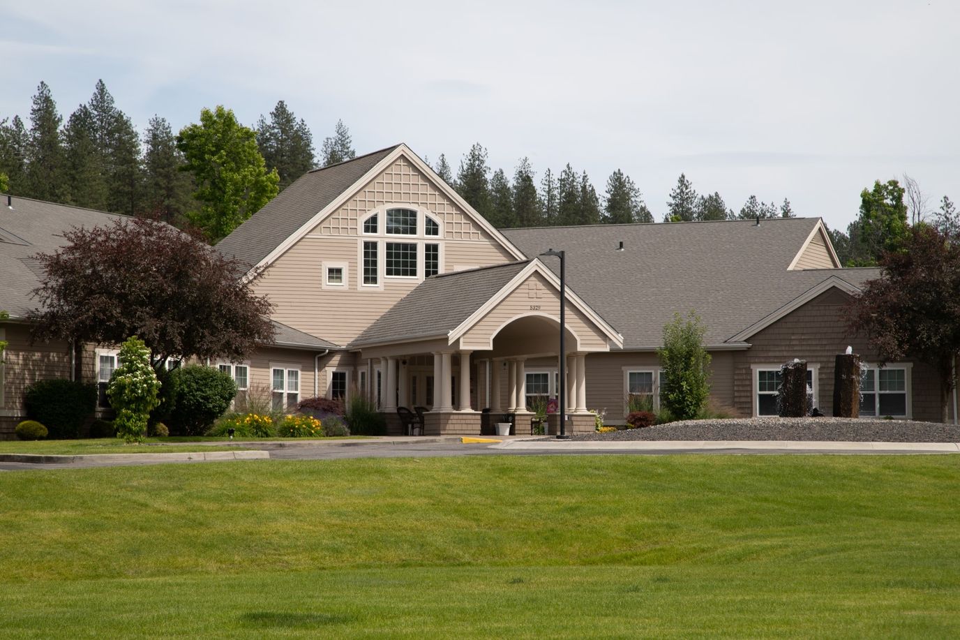 Exterior view of a senior living facility surrounded by gardens