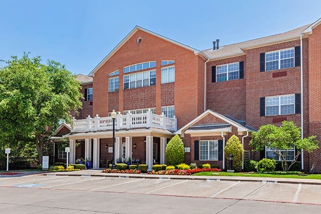Exterior view of a senior living facility with landscaping