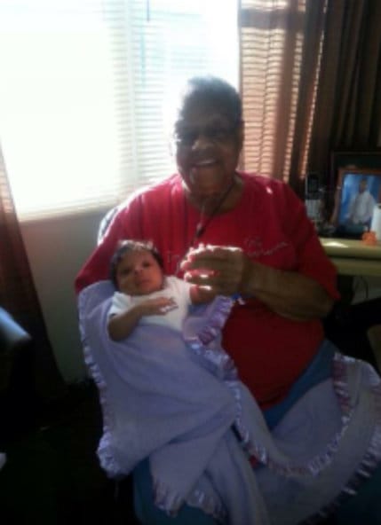 Elderly woman happily holding a baby