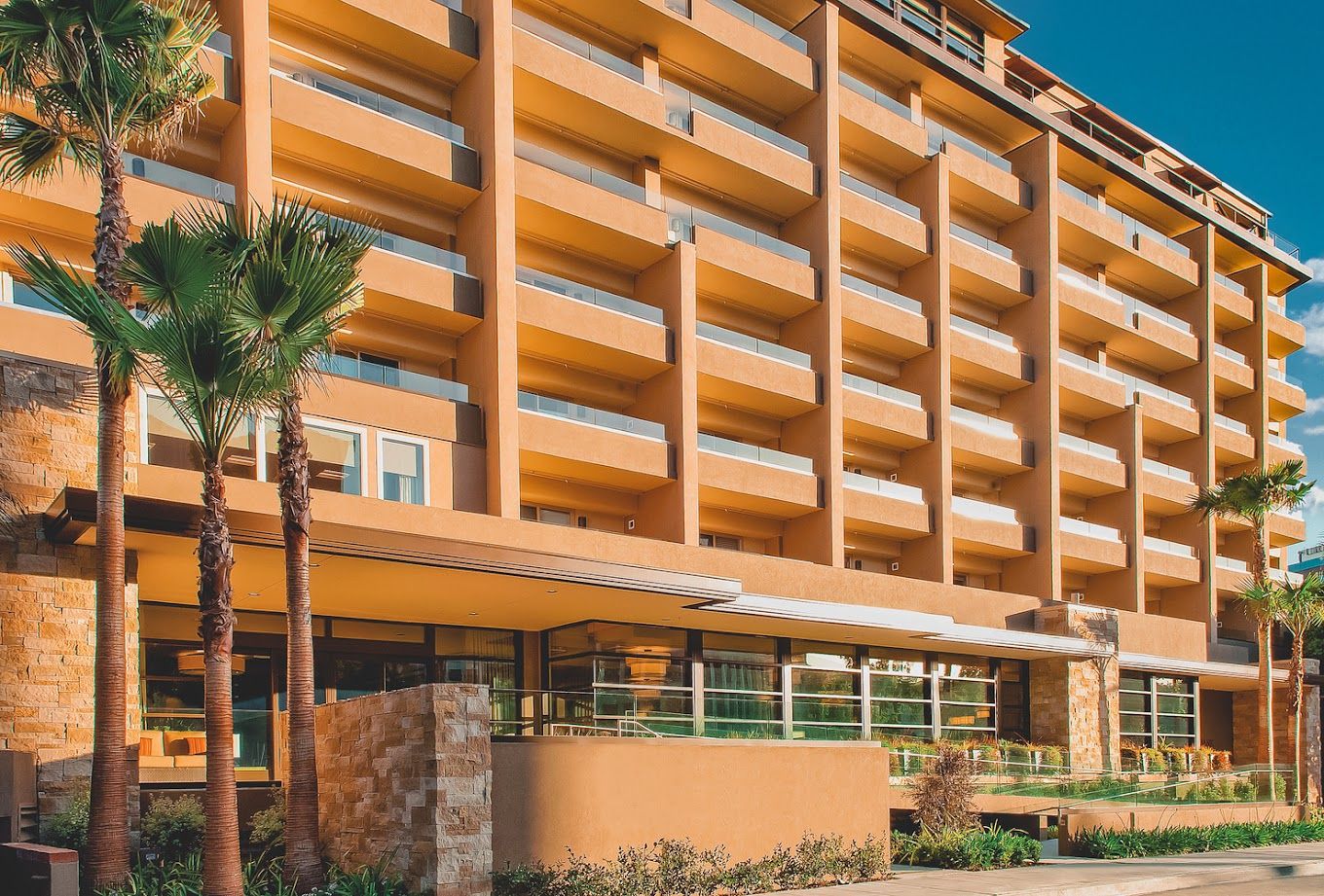 Exterior view of the facility building with balconies and palm trees