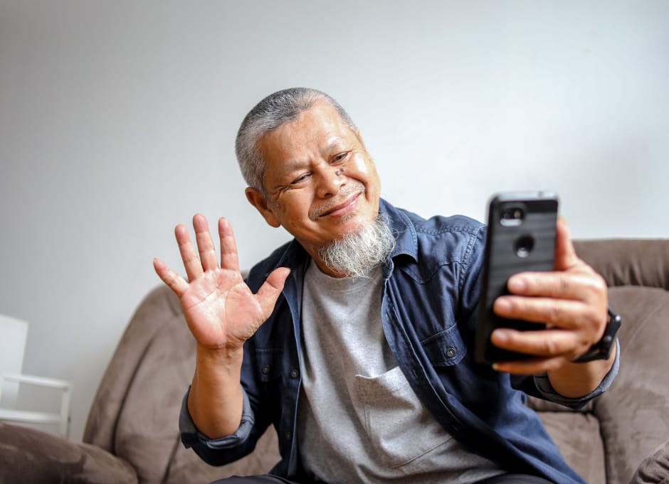Resident using a phone and waving.
