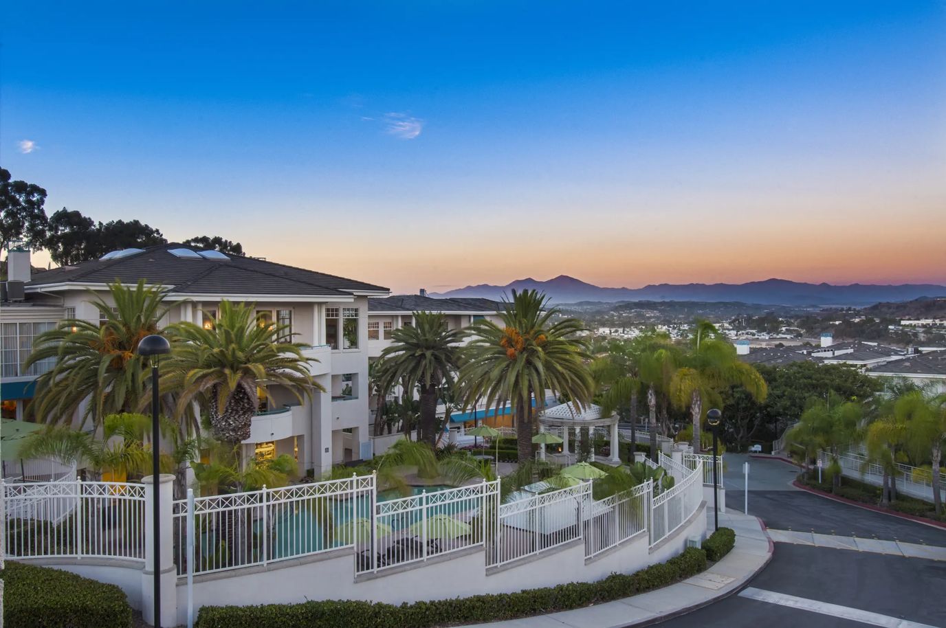 Exterior view of Sea Bluffs with palm trees and sunset