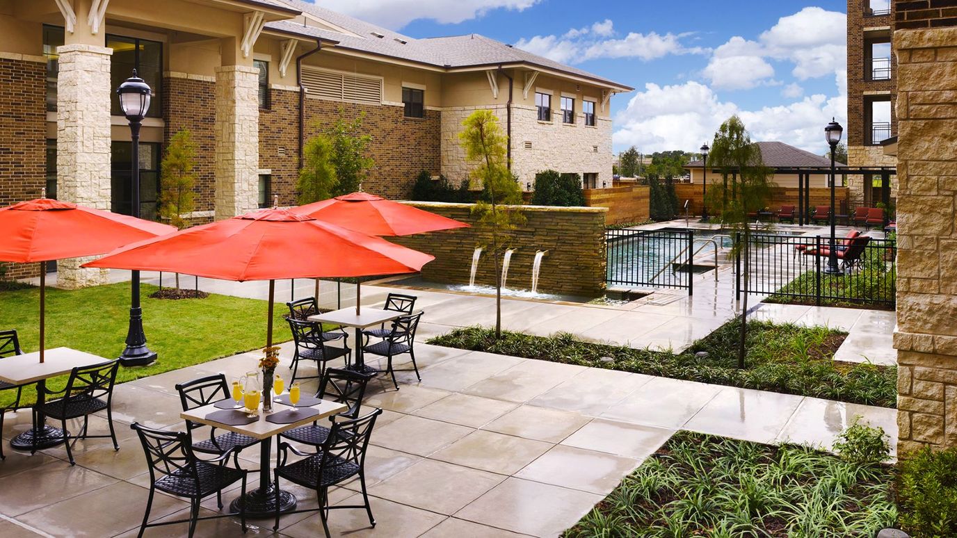 Outdoor seating with umbrellas and pool area.