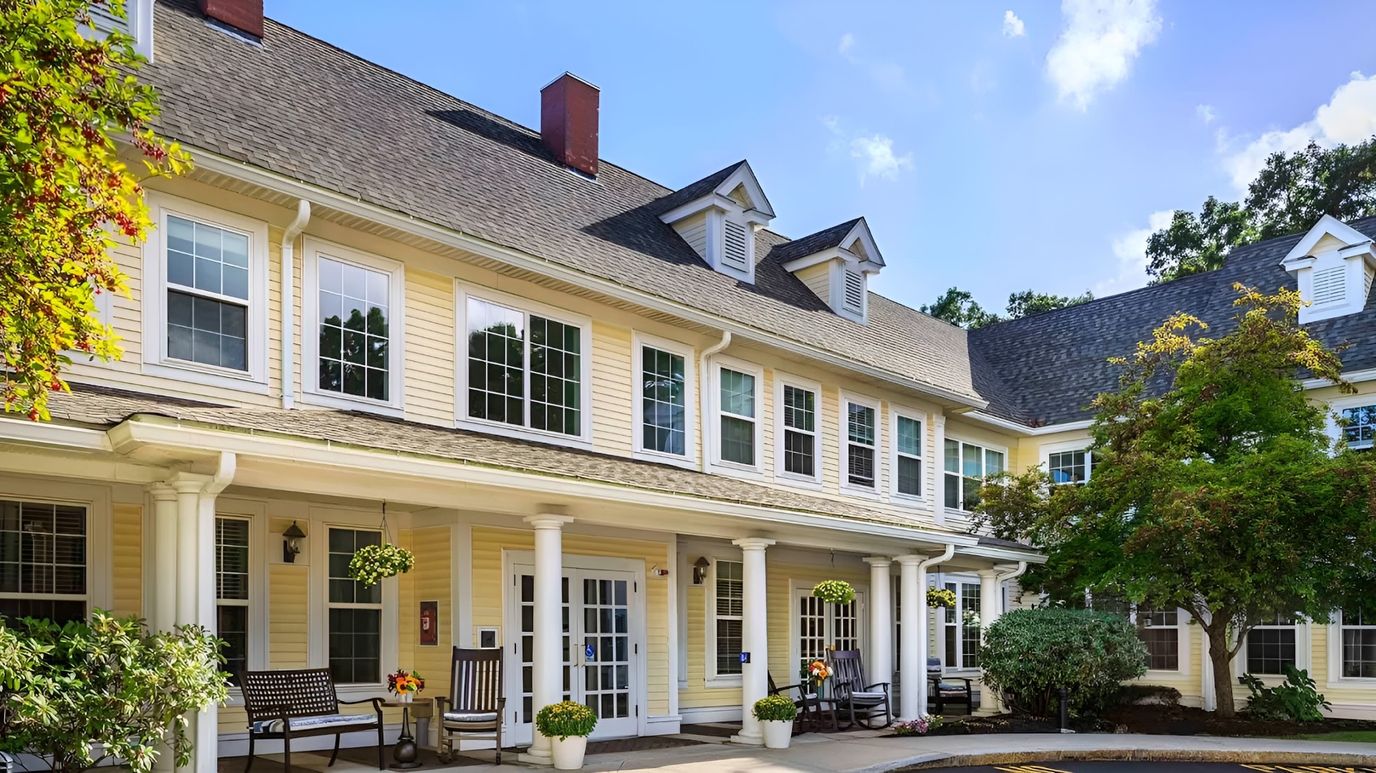 Exterior view of Atria Merrimack Place with porches and gardens