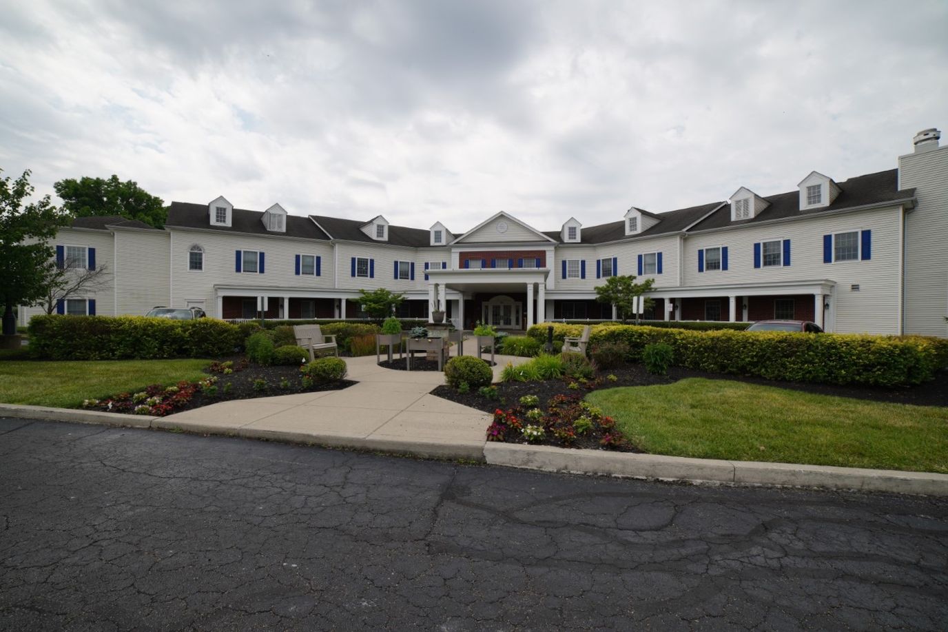 Exterior view of a senior living facility with gardens