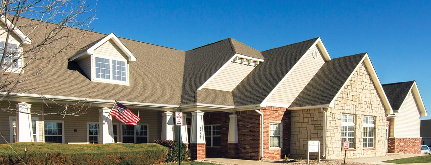 Exterior view of a senior living facility with gardens