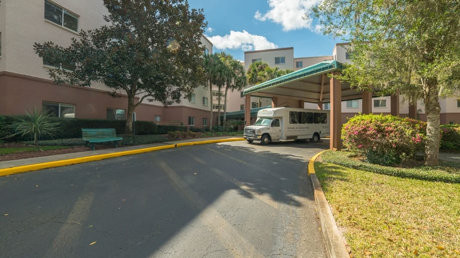 Entrance area with facility transport van and landscaping