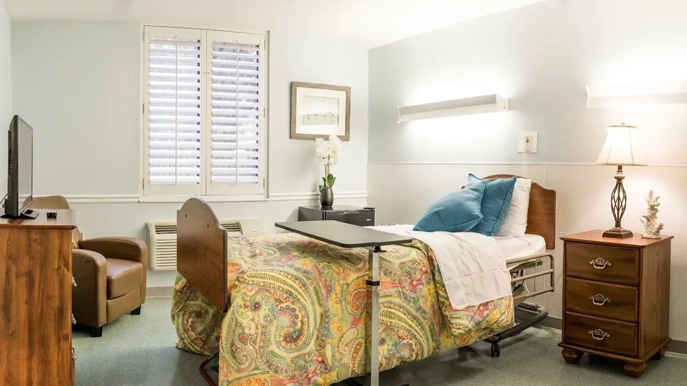 Private resident room with a bed and comfortable chair
