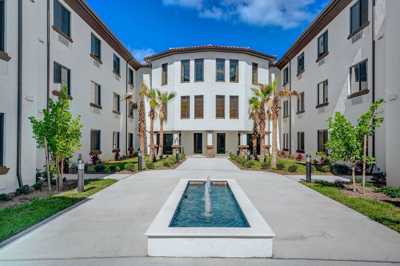 Outdoor courtyard with a fountain and palm trees