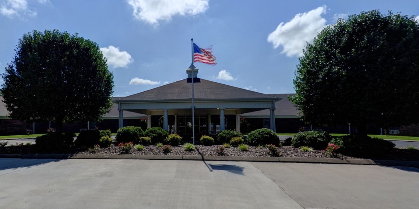 Exterior view of Village Manor Assisted Living with landscaping