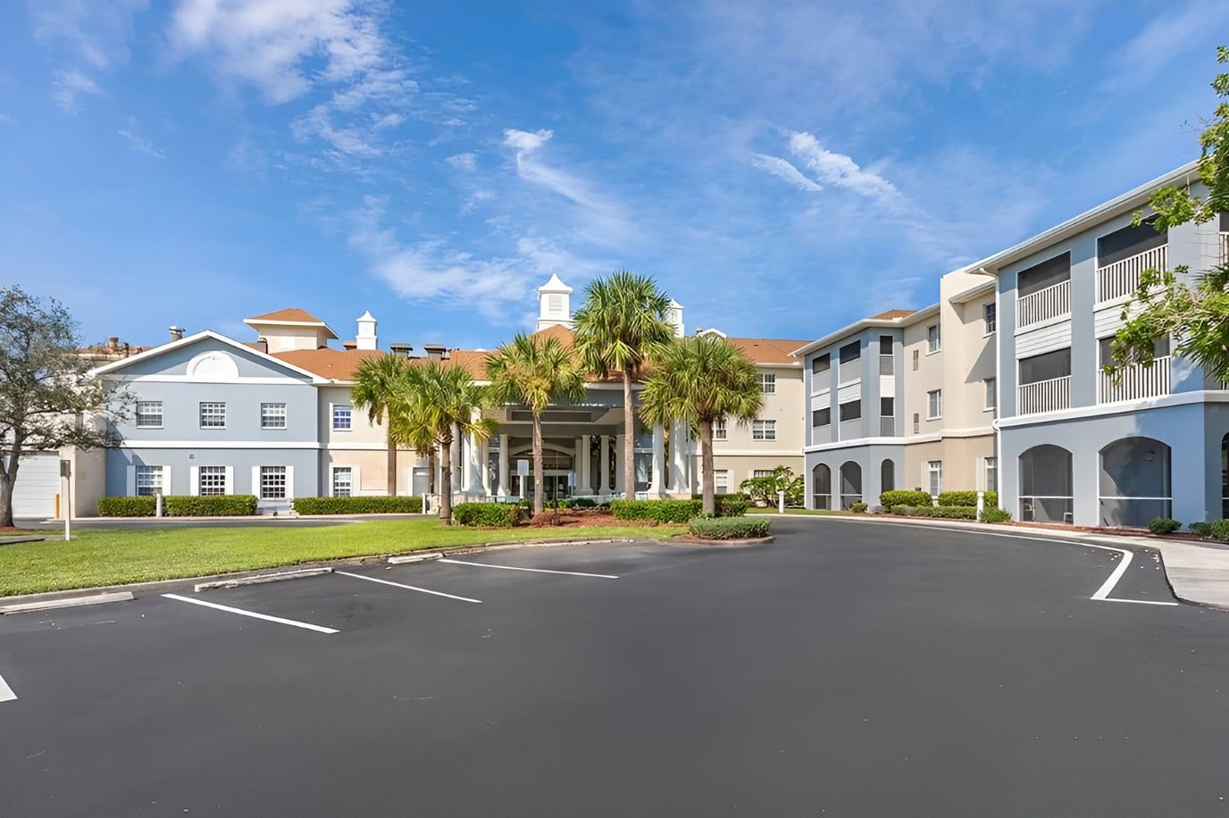 Exterior view of a senior living facility with palm trees