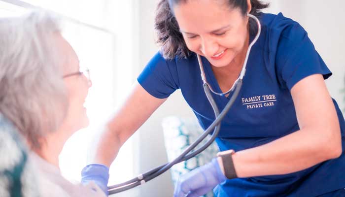 Nurse using a stethoscope to assist a senior resident