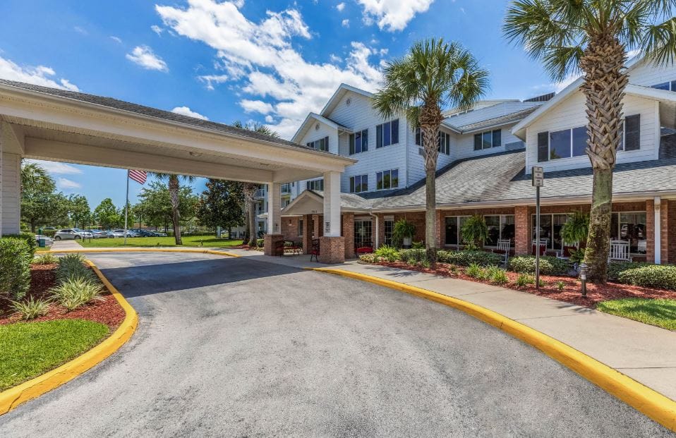 Entrance of a senior living community with palm trees