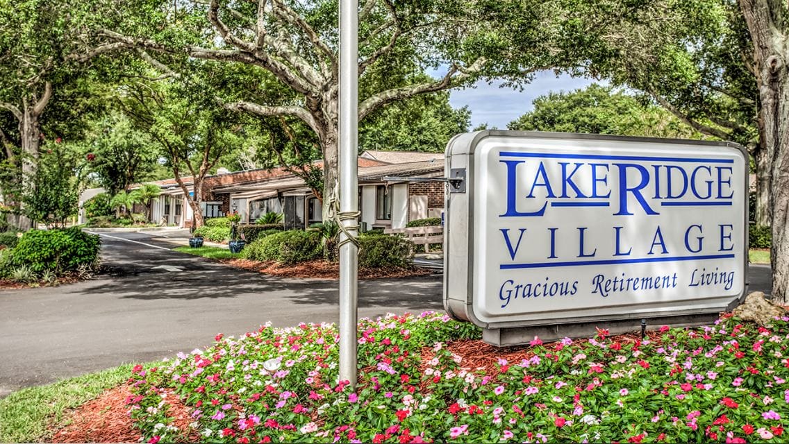 Entrance sign of Lake Ridge Village with landscaped flowers