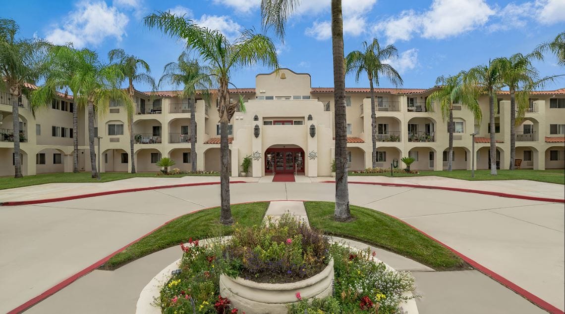 Exterior view of a senior living facility with gardens