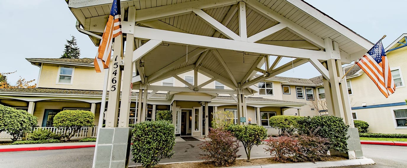 Entrance of Brookdale Monroe with flags and landscaping