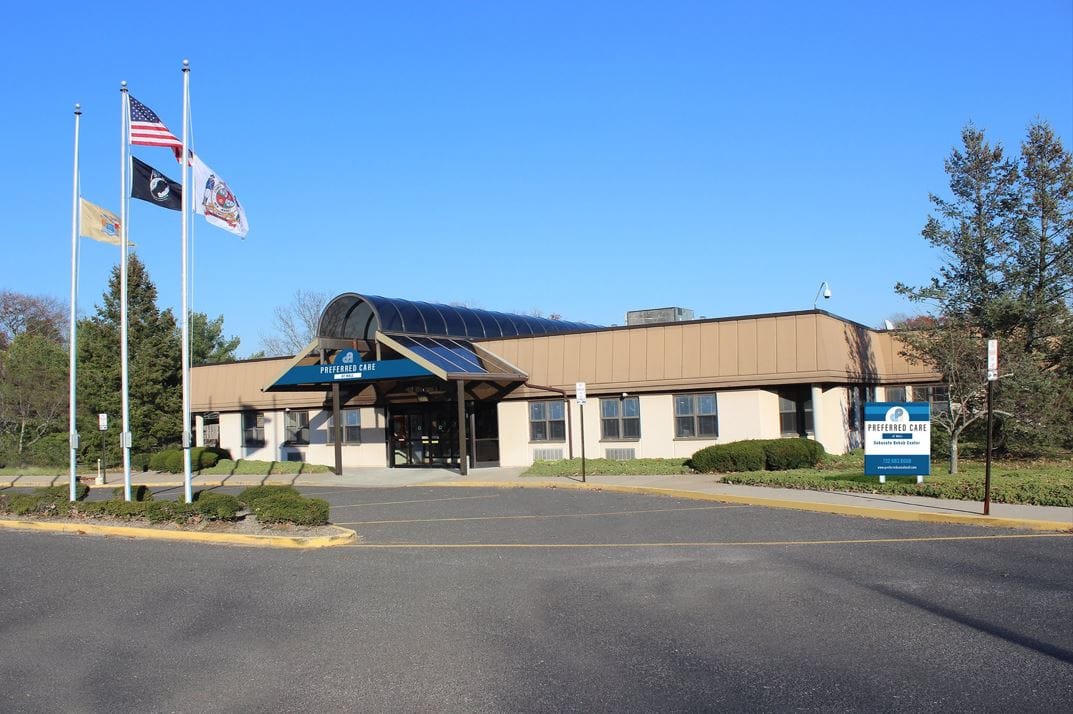 Exterior view of Preferred Care facility with flags