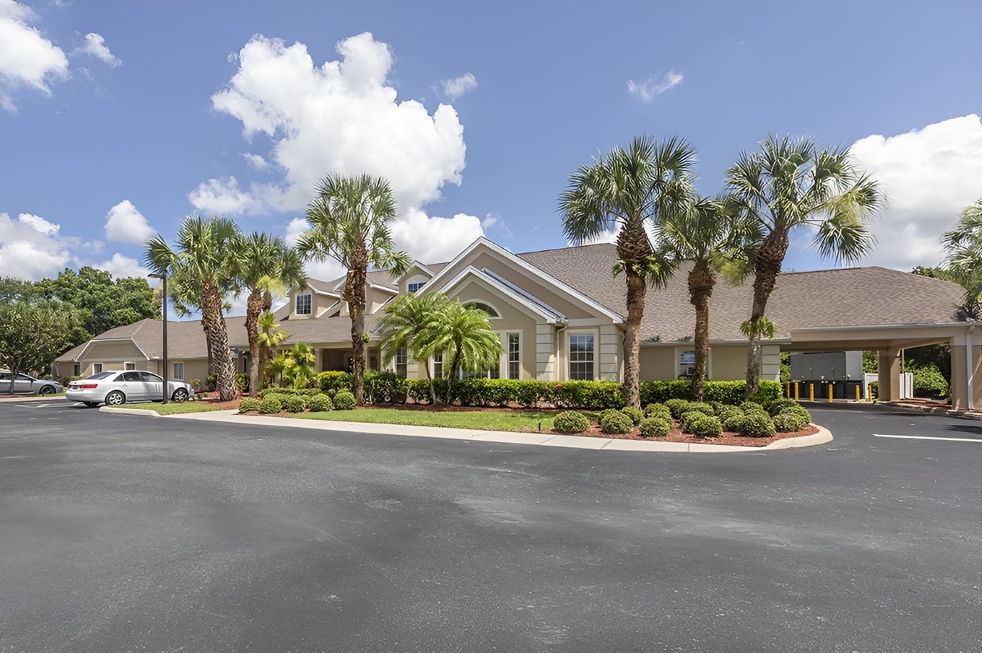 Exterior view of Brookdale Port Charlotte with palm trees