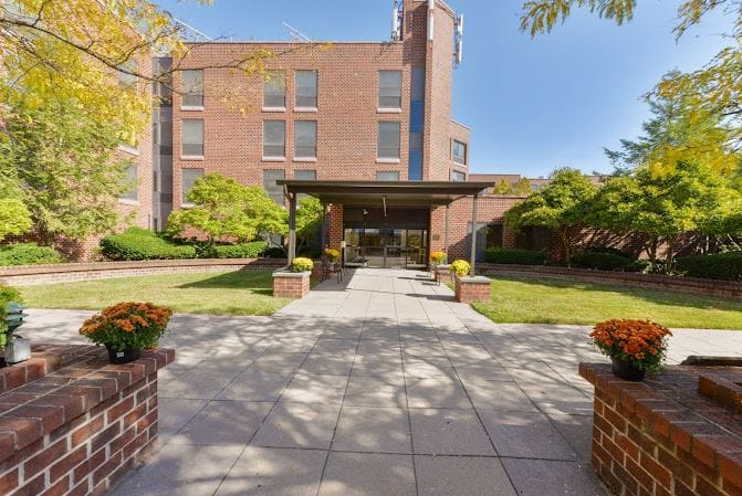 Exterior view of Runnells Care Center with garden