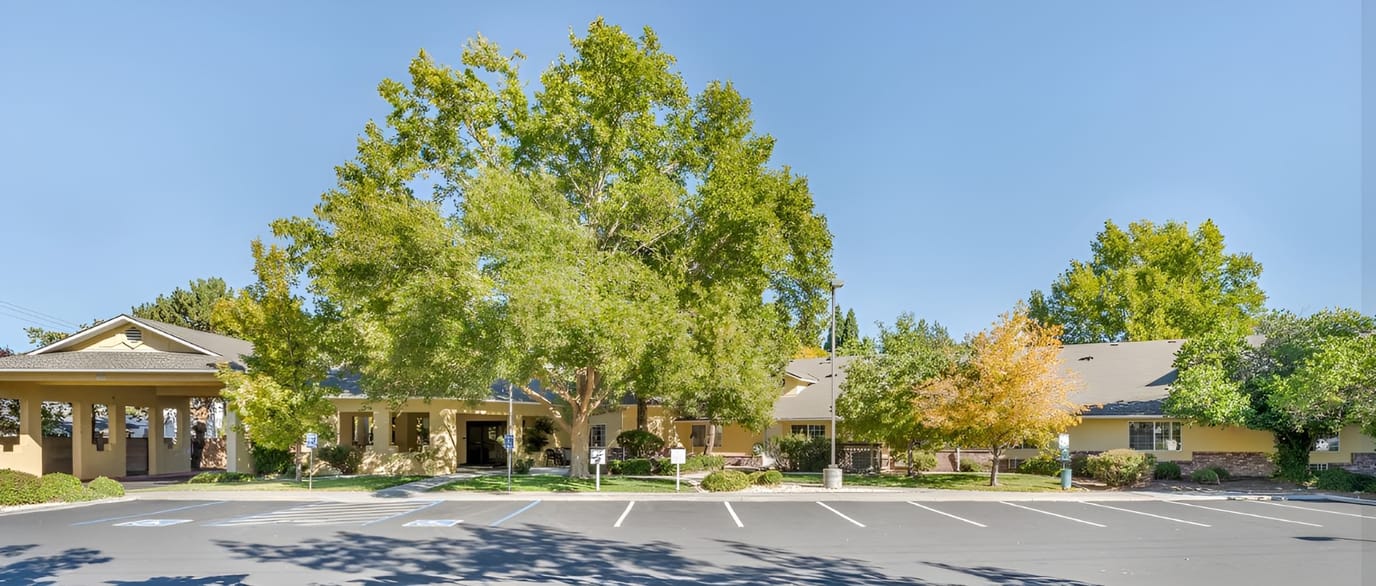 Exterior view of a senior living facility surrounded by trees