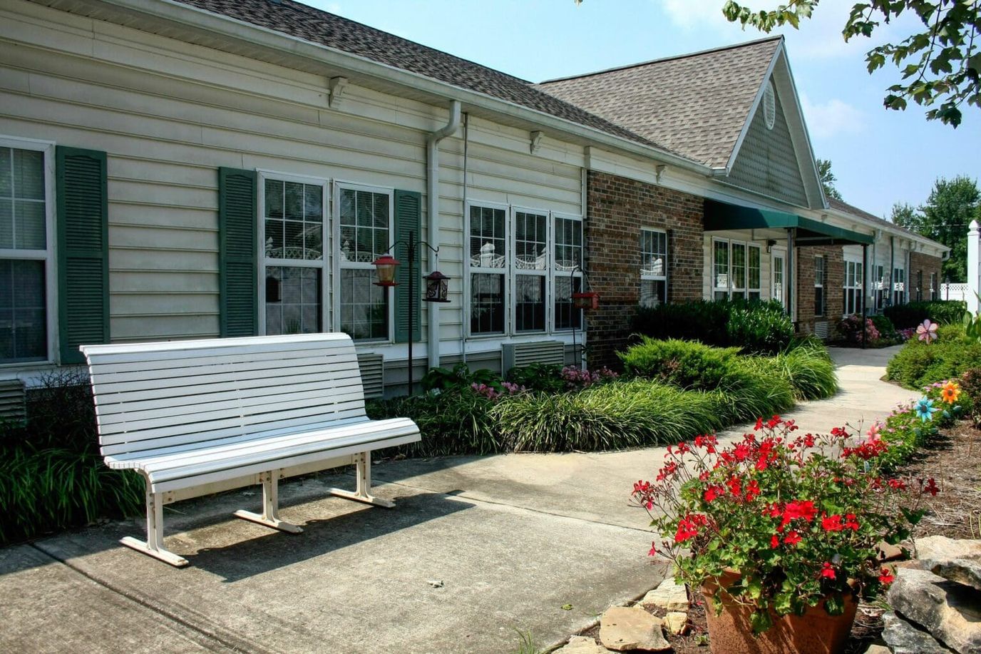 Exterior view of a senior living facility with flower beds