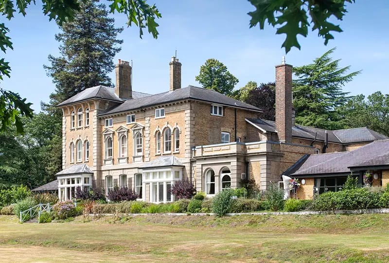 Exterior view of Merlewood Care Home surrounded by greenery