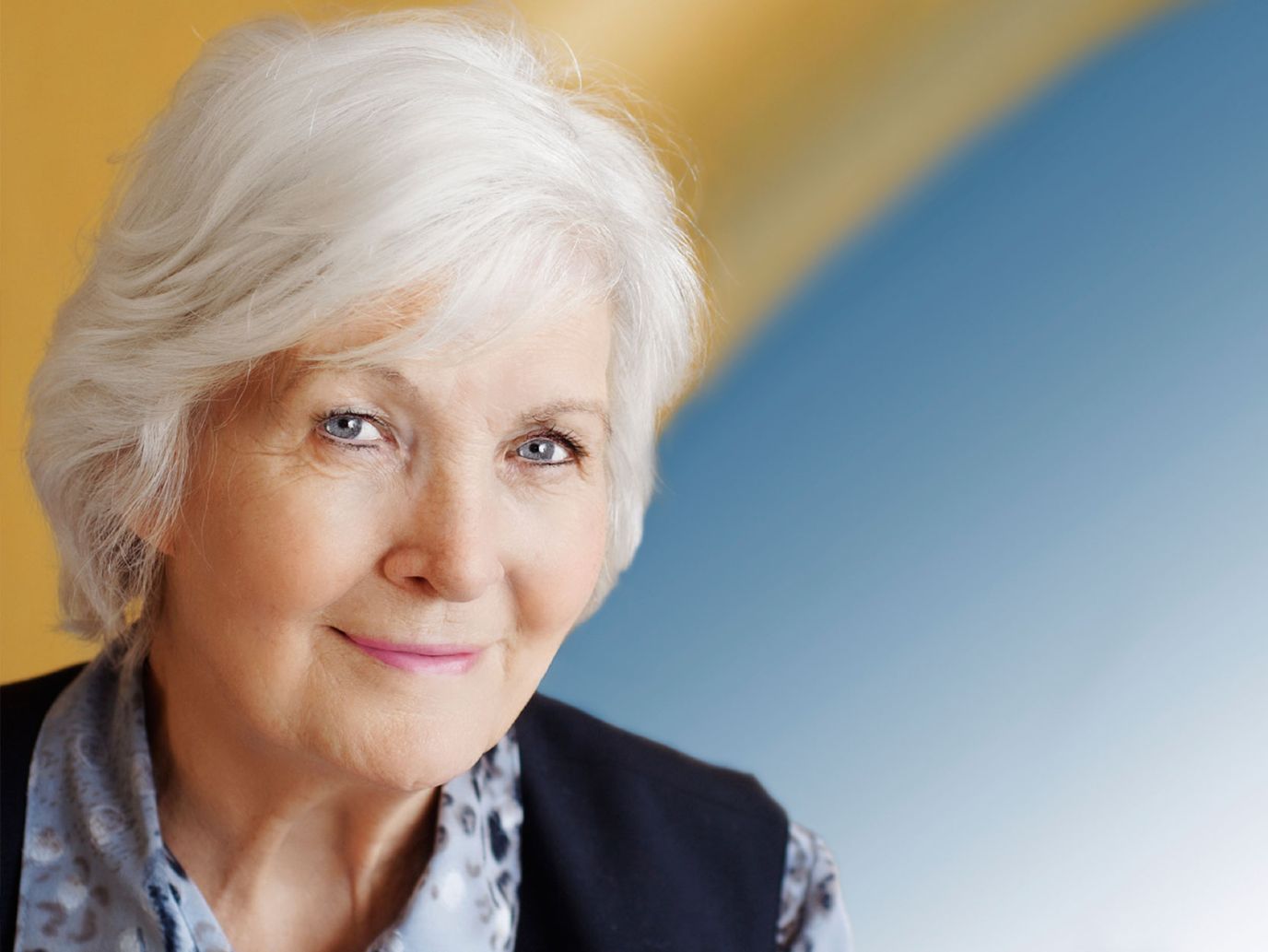 Elderly woman with white hair smiling softly