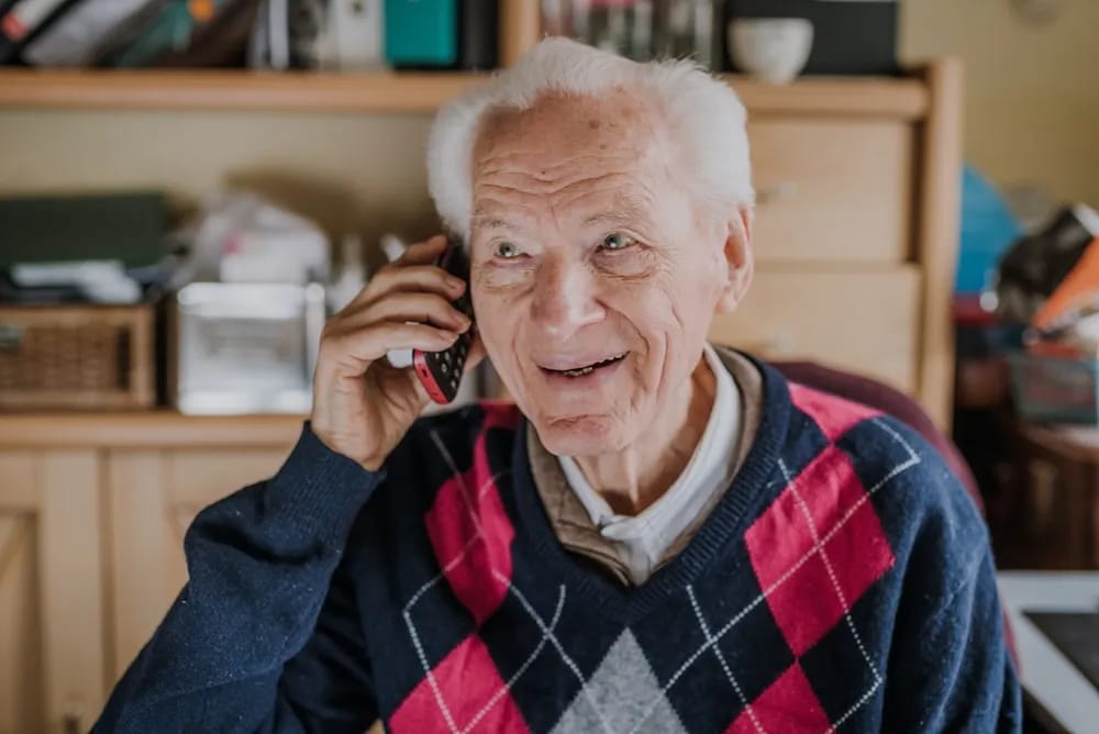 Senior man joyfully speaking on the phone