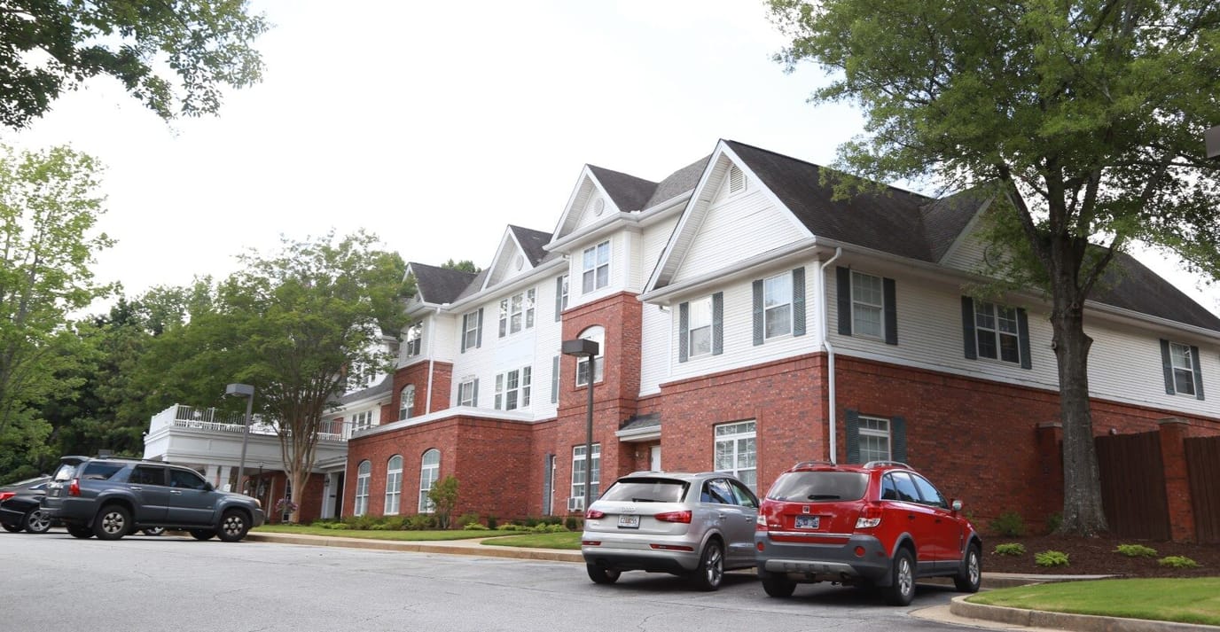 Exterior view of the Charter Senior Living building with cars parked