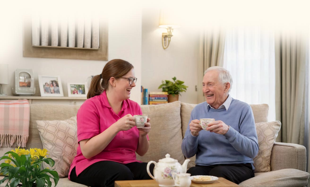 A caregiver and a resident enjoying tea in a cozy living area