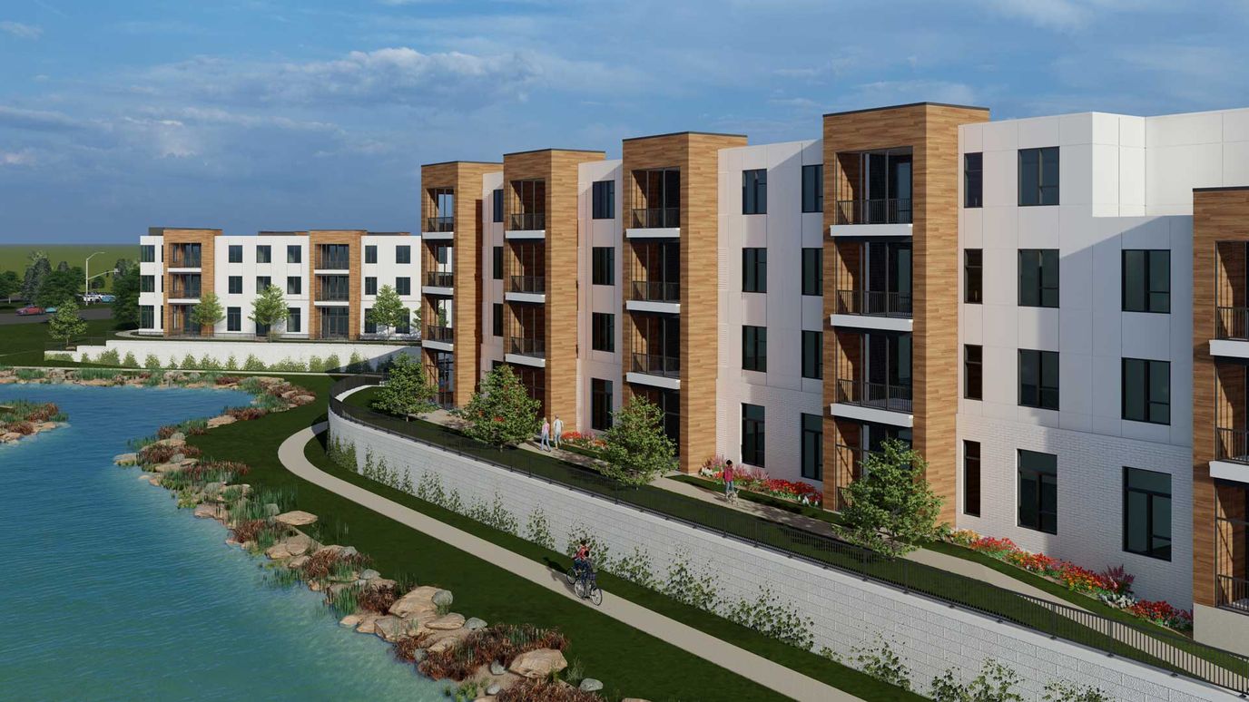Exterior view of a modern assisted living facility by a serene water body