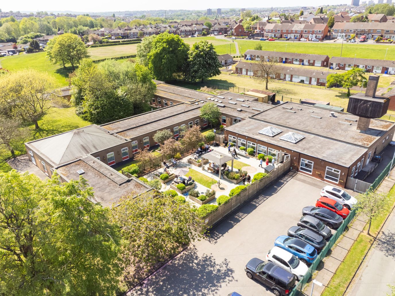 Aerial view of a nursing facility with gardens and parking