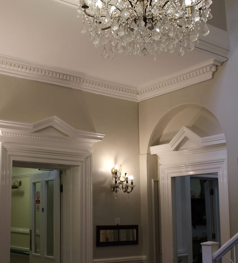 Elegant lobby area with chandelier and lights.
