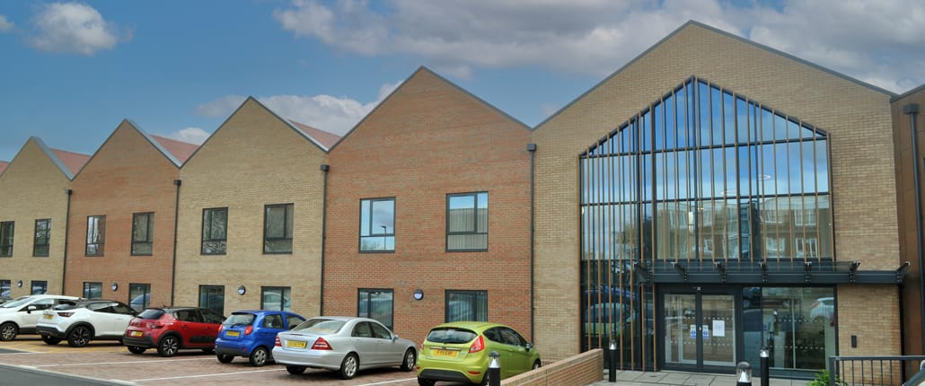 Exterior view of a senior care facility with parked cars