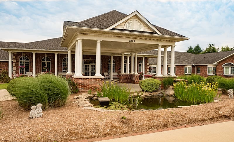 Exterior view of Charter Senior Living facility with pond