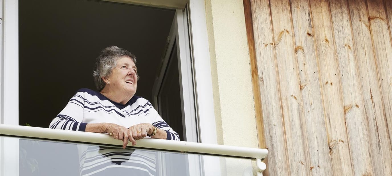 Senior woman smiling on her balcony