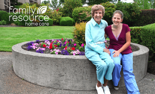 Senior resident and staff member in garden area