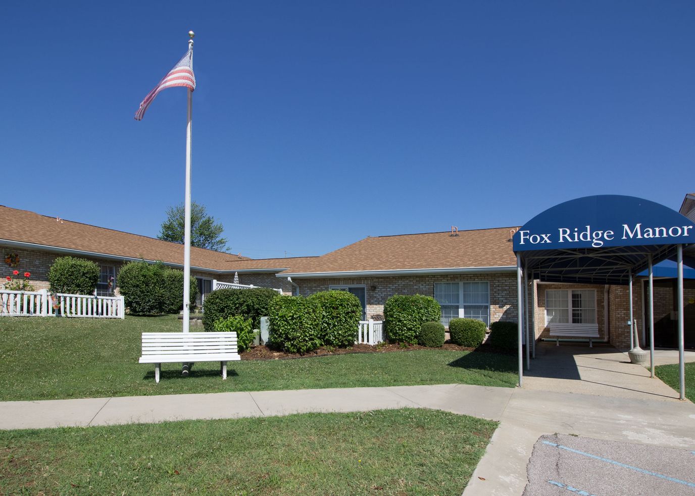 Exterior view of Fox Ridge Manor with flag and entrance awning