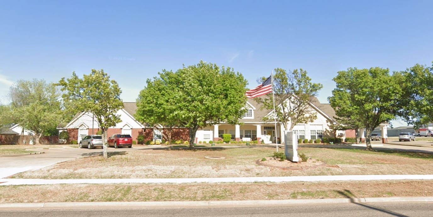 Exterior view of Brookdale Shawnee with trees and flag