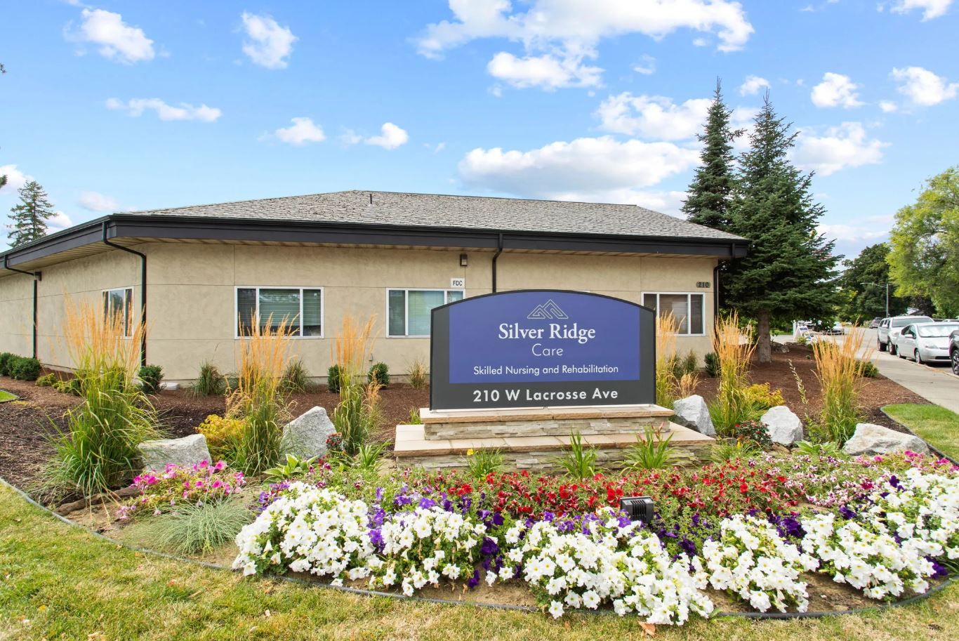 Exterior view of Silver Ridge Care facility with signage and flowers