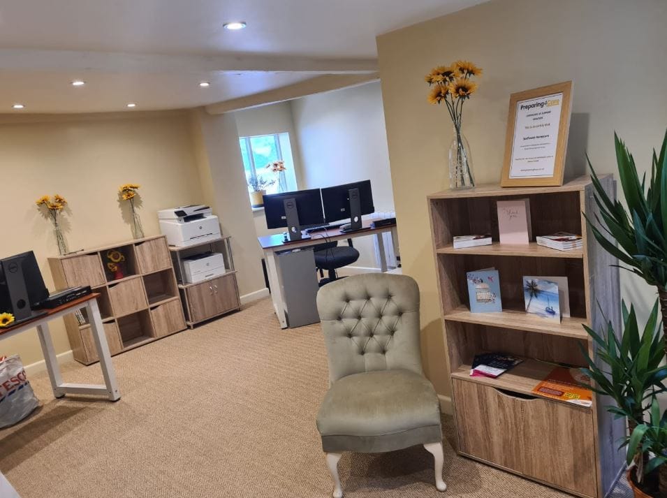 Interior view of an office space with a chair, shelves, and computers.