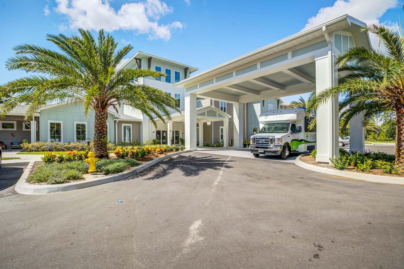 Entrance of The Canopy at Hickory Creek with landscaping and a transport vehicle