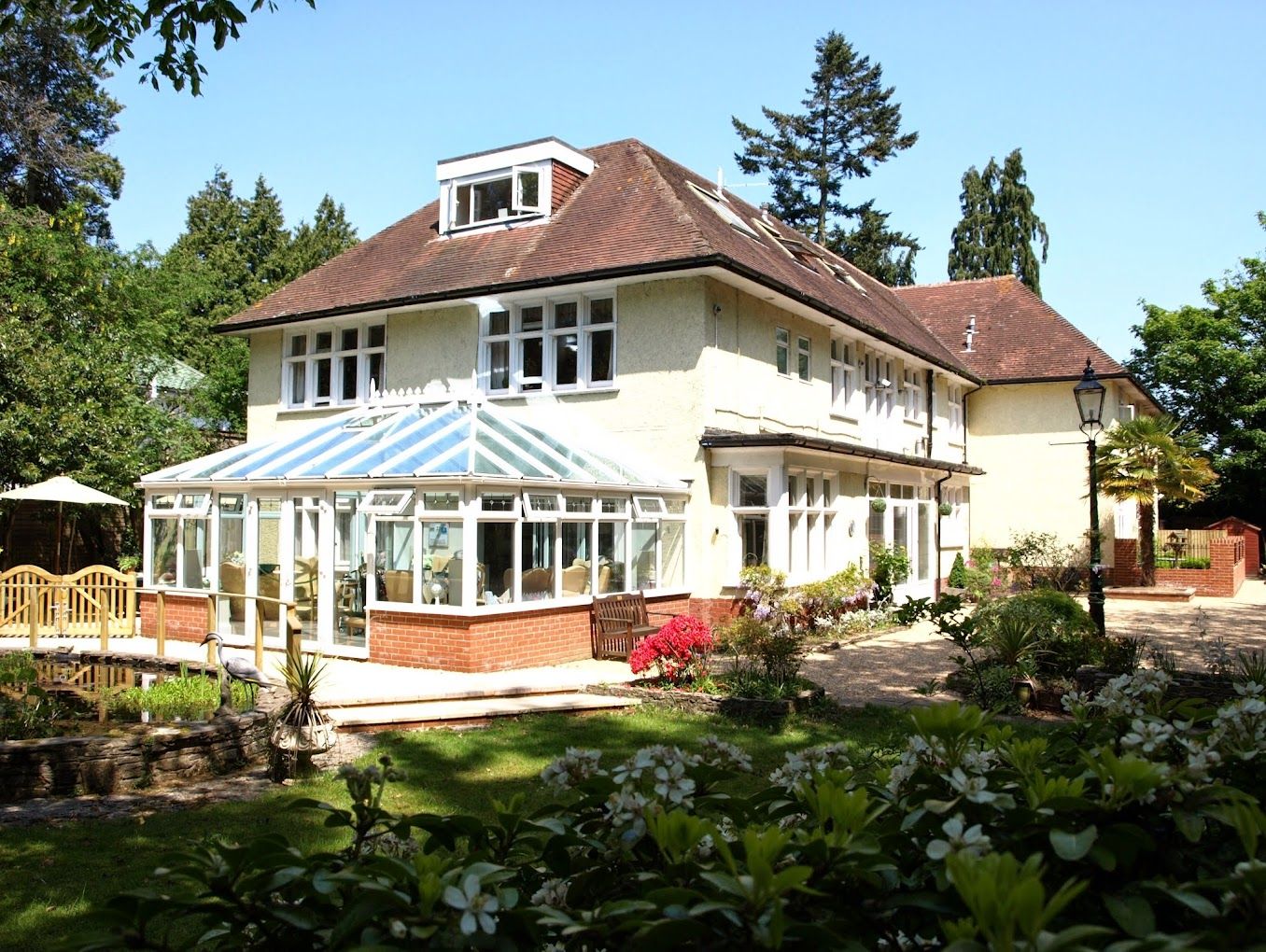 Exterior view of The Evergreens Care Home with garden